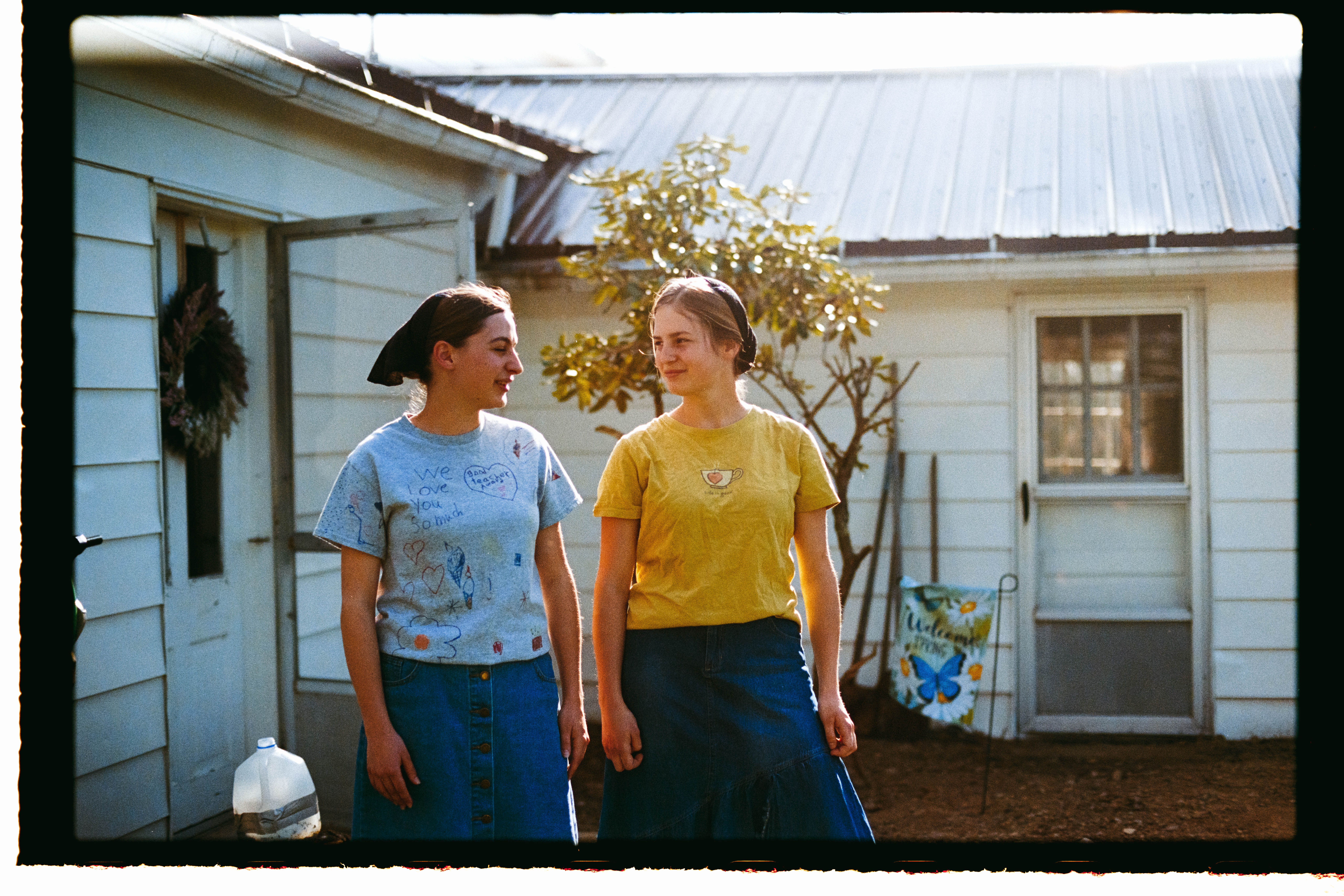 Two of Jo's daughters standing in front of their house