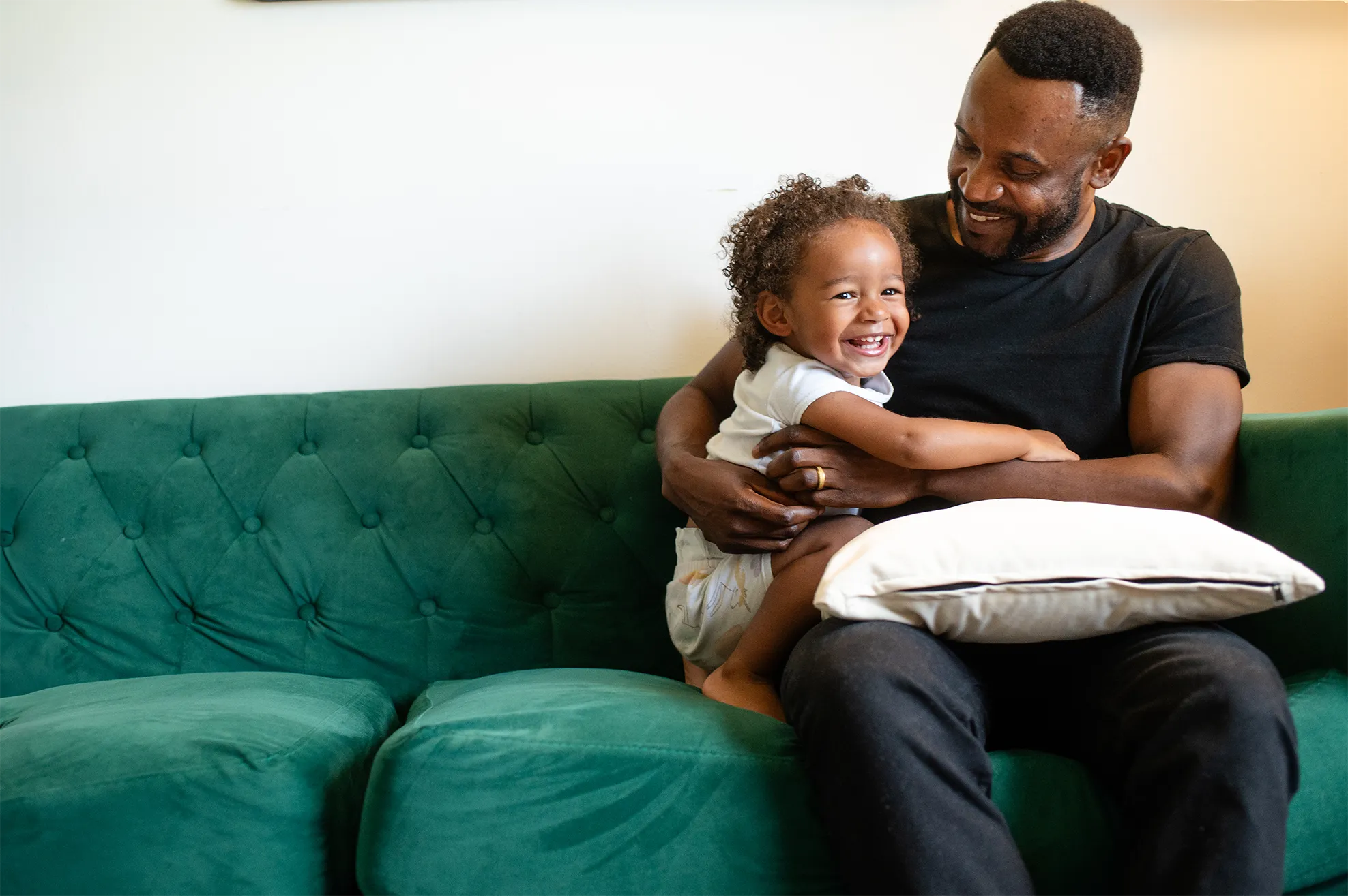 Jon sitting on a couch with his daughter.
