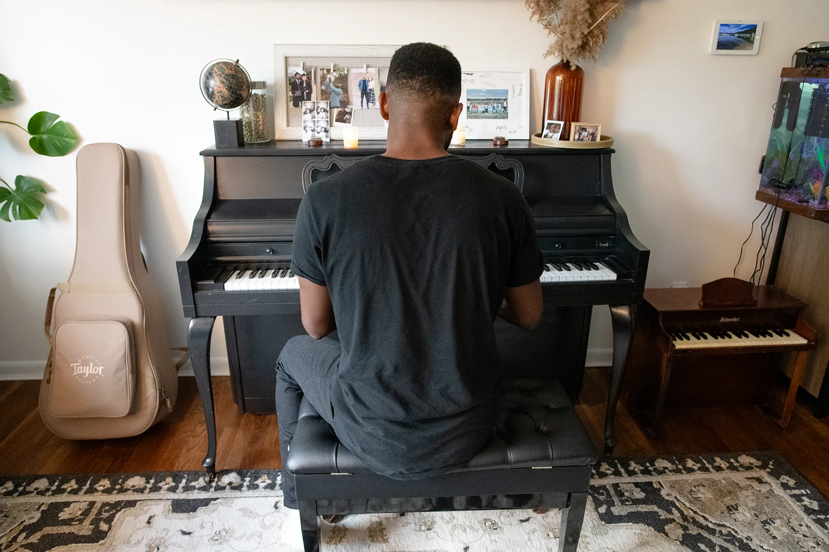 Jon sitting at a baby grand piano.