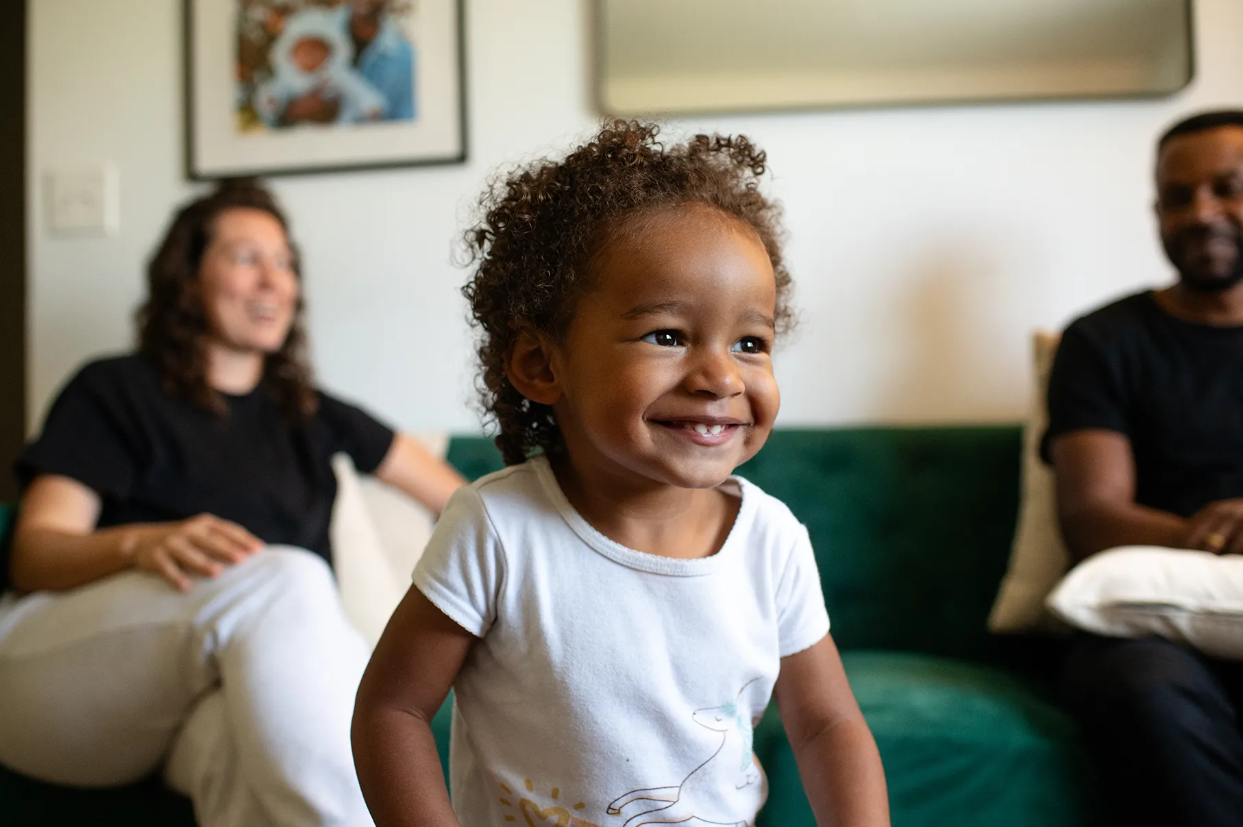 Jade playing while her parents watch from the couch